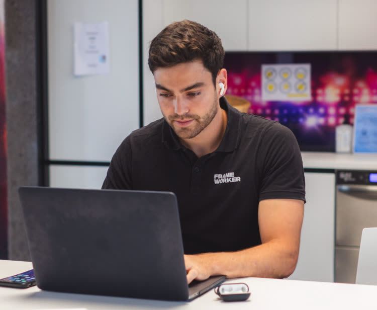 Michael Bayreder arbeitet am Laptop im FRAMEWORKER-Shirt