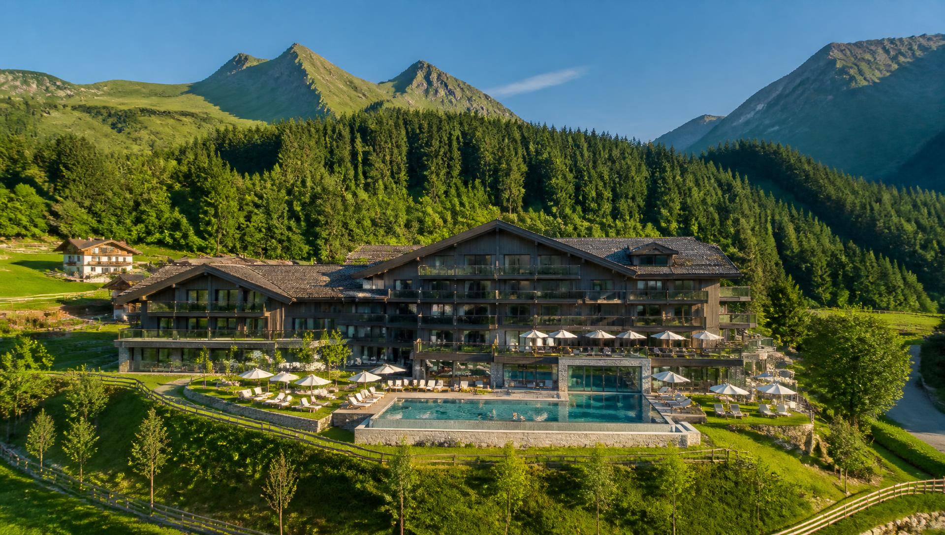 AI-generierte Drohnenaufnahme eines Alpenresorts im Sommer — Demo